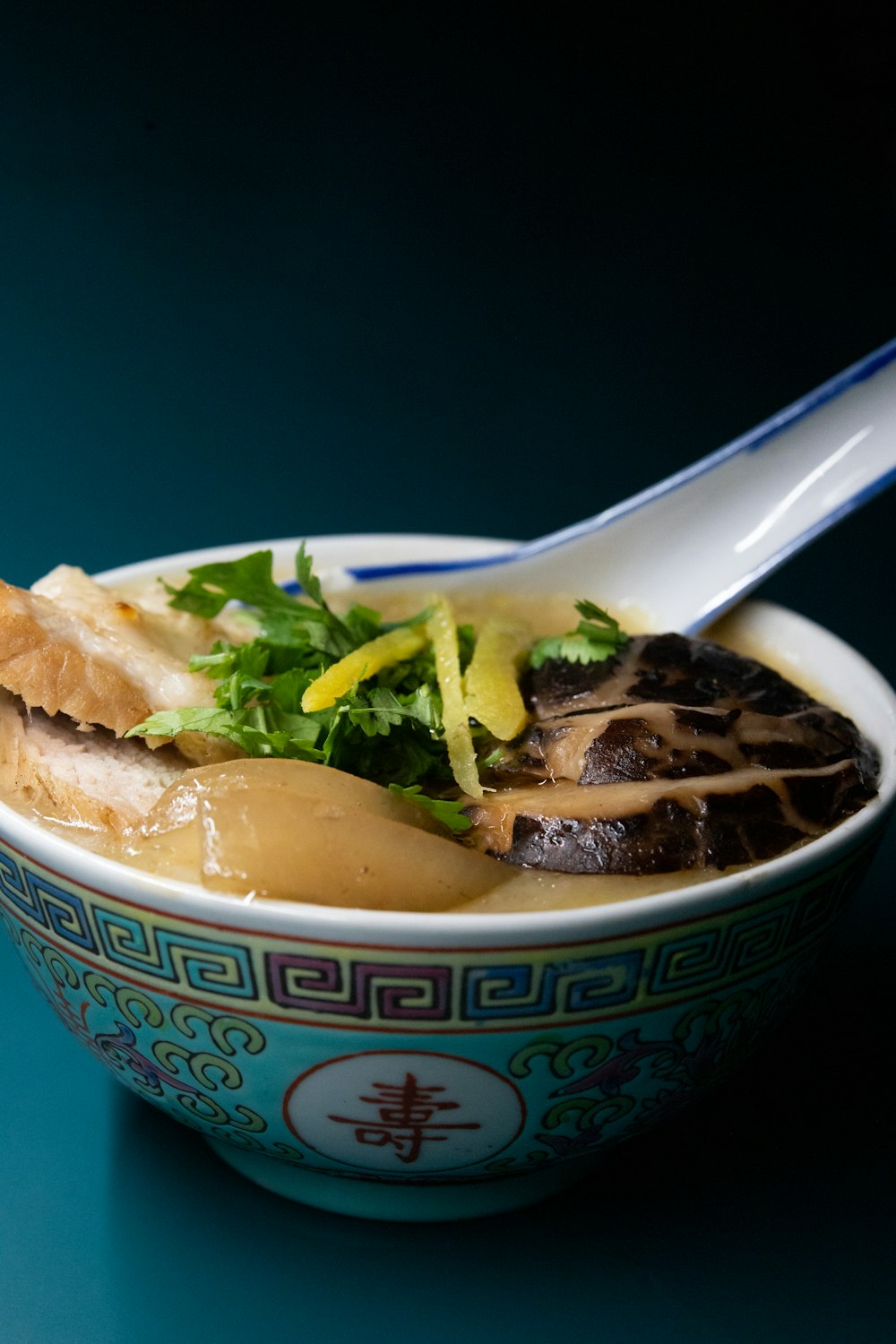 white and blue ceramic bowl with soup