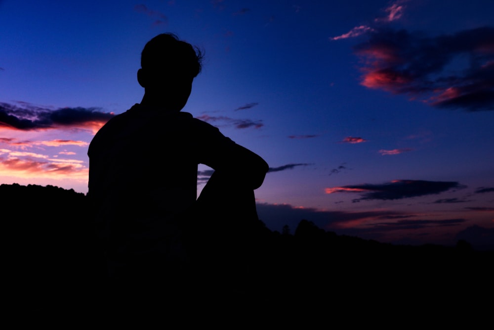 silhouette of man under blue sky during sunset