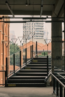 A sleek metal staircase winding upward inside a modern industrial building.
