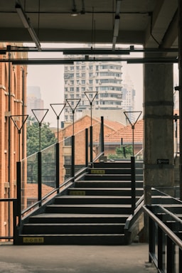 A sleek metal staircase winding upward inside a modern industrial building.
