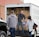 A delivery truck unloading construction materials at a retail building supply store.
