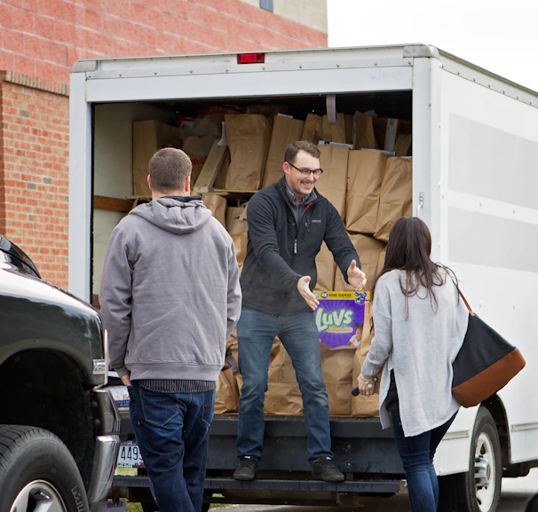 A mother gratefully receiving baby supplies from a HopeHarbor volunteer