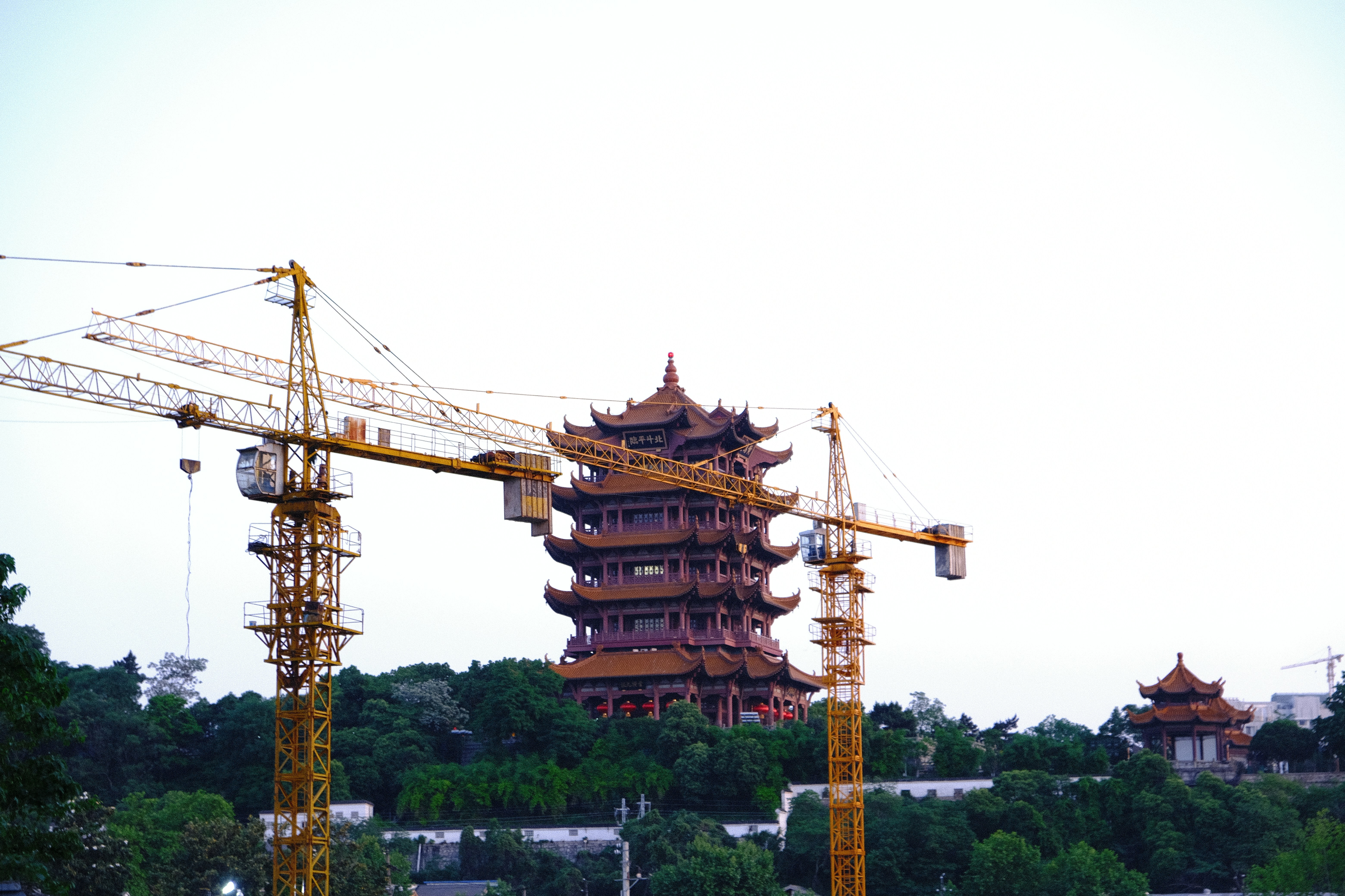 brown wooden tower near green trees during daytime