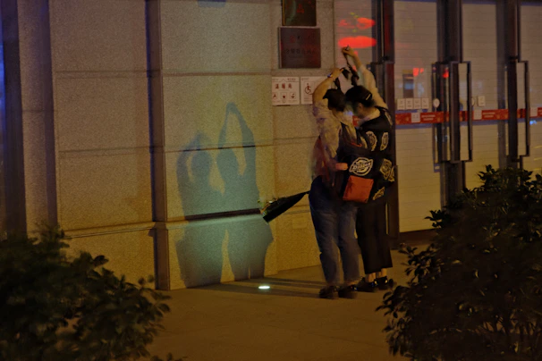 Shaman & Daisy mid-laugh, caught in the middle of a strange wobble dance on a vibrant city street.