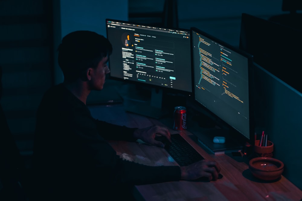 hombre en camisa negra de manga larga usando la computadora