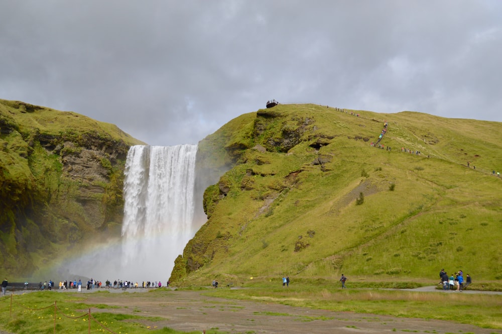 a group of people standing in front of a waterfall