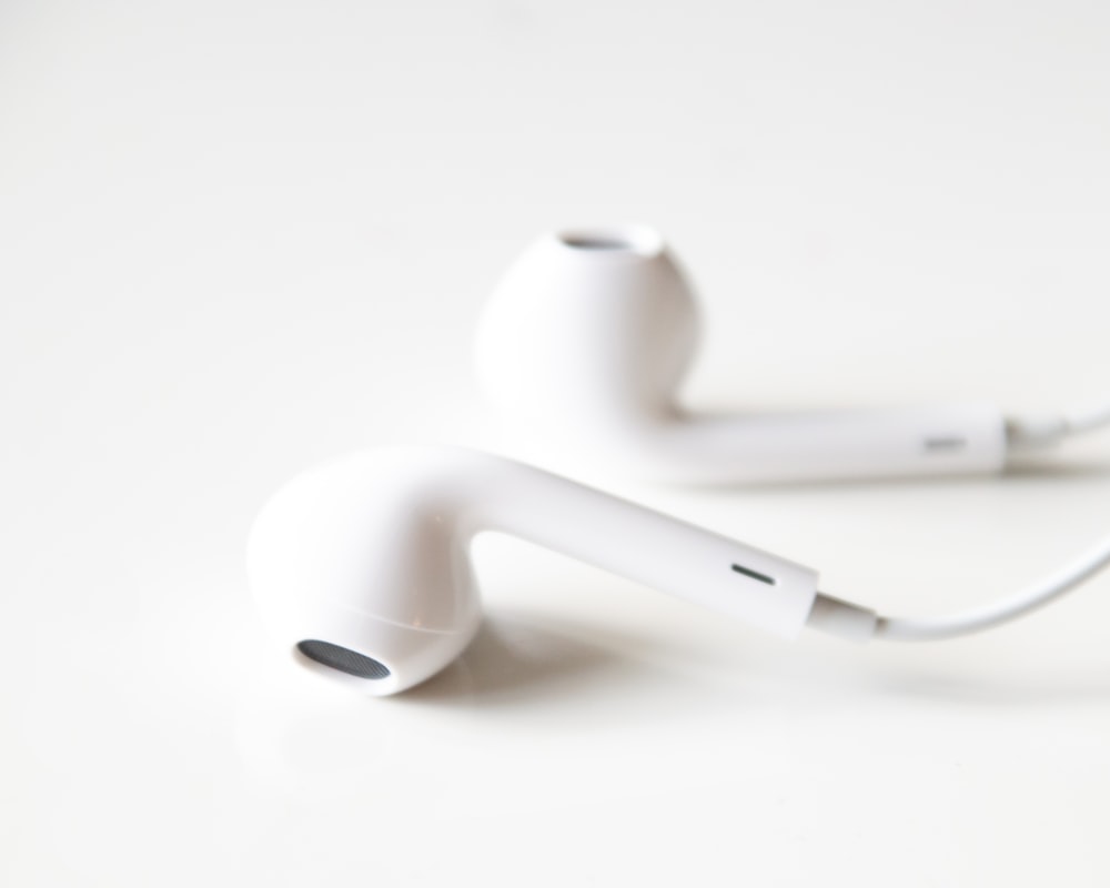 white apple earpods on white surface