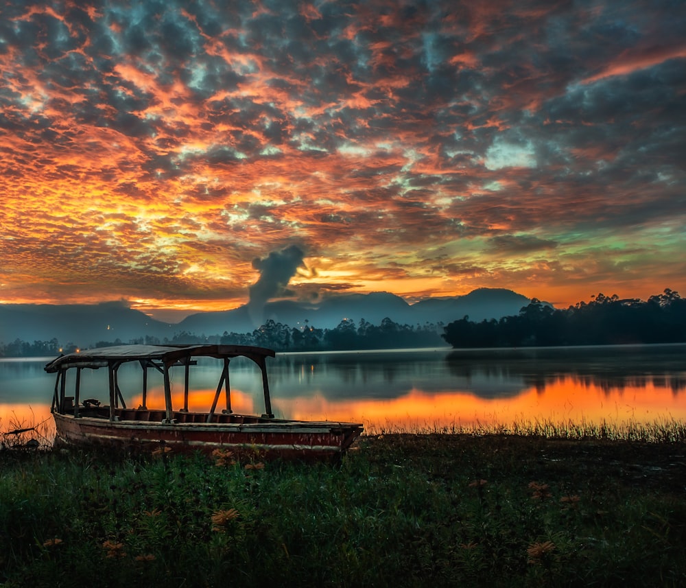 brown wooden dock on lake during sunset