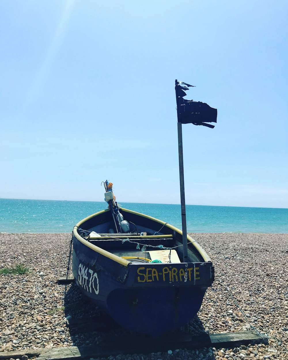 black and white boat on beach during daytime