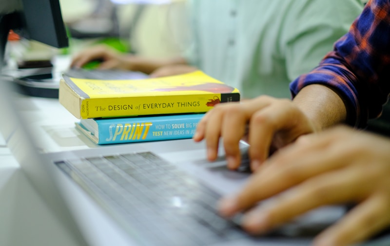 Student studying architecture online with laptop and books on desk