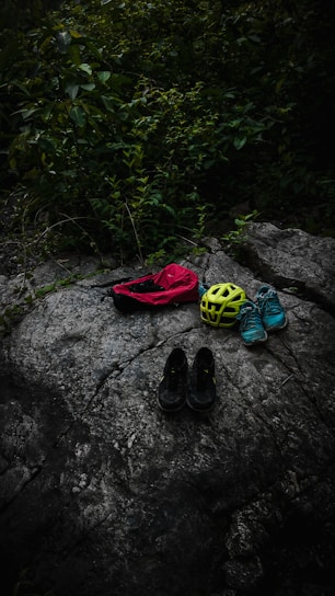 A collection of mountaineering bags displayed on a rocky surface.
