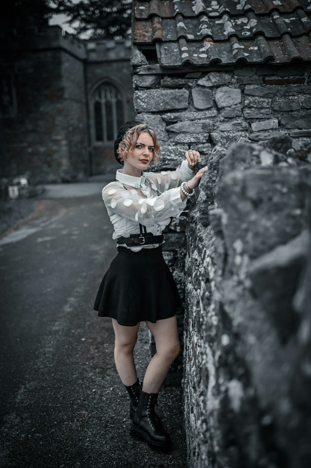 woman in white long sleeve shirt and black skirt standing on road during daytime