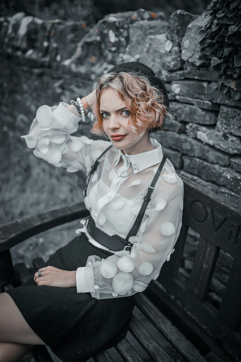 woman in white and black long sleeve shirt sitting on black wooden bench