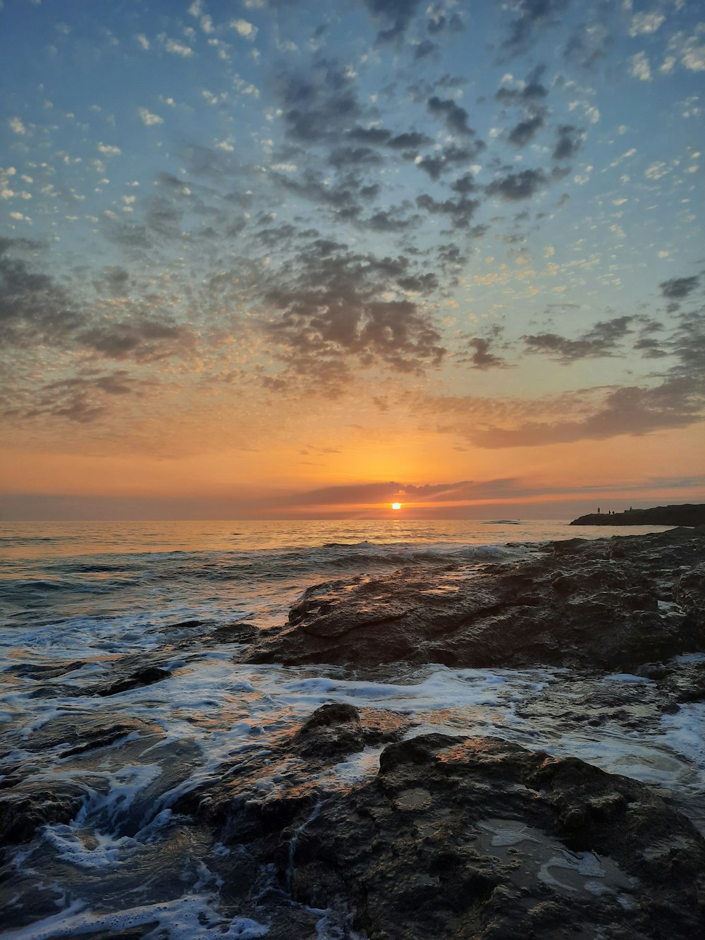 ocean waves crashing on rocks during sunset