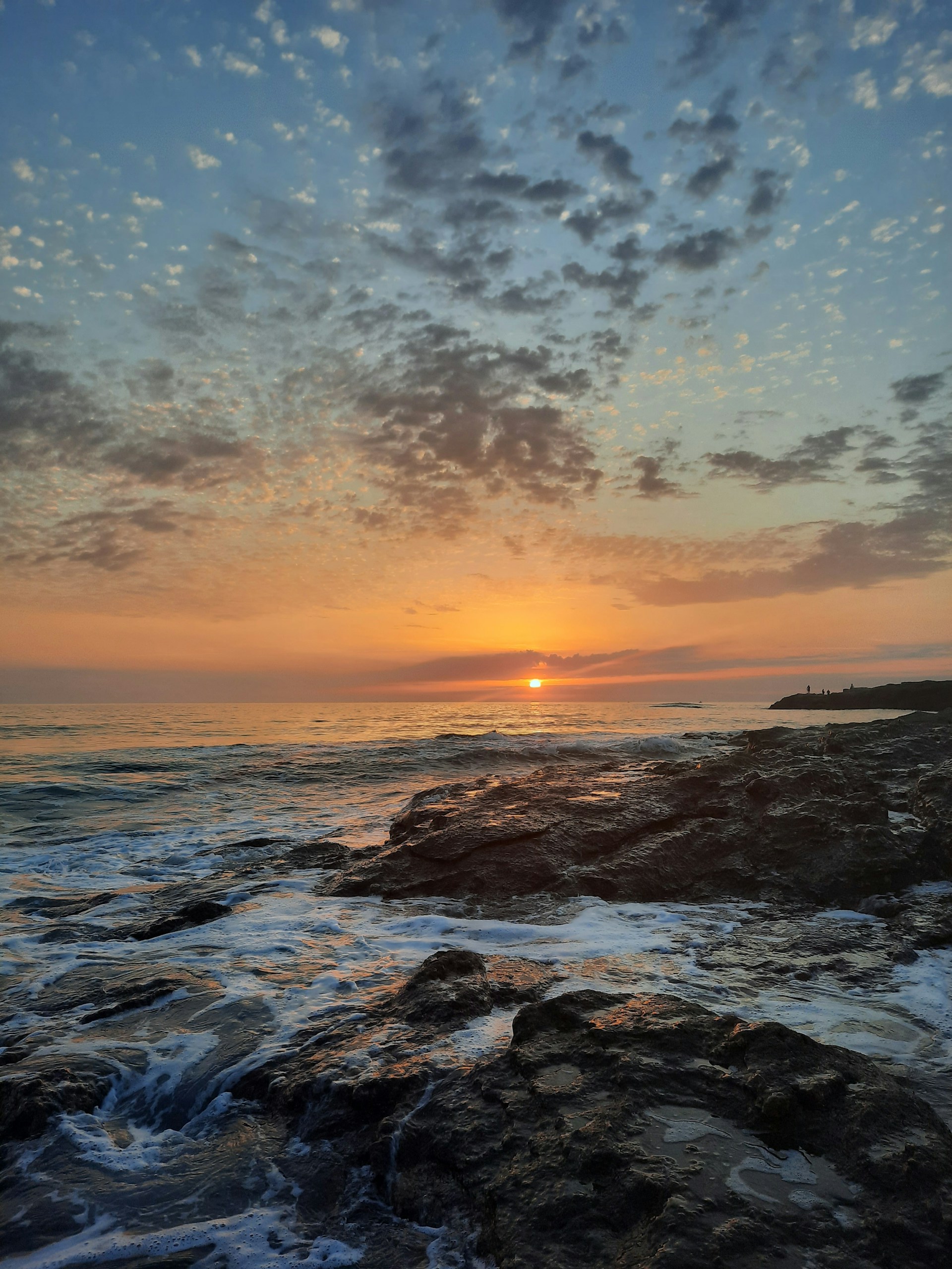 ocean waves crashing on rocks during sunset