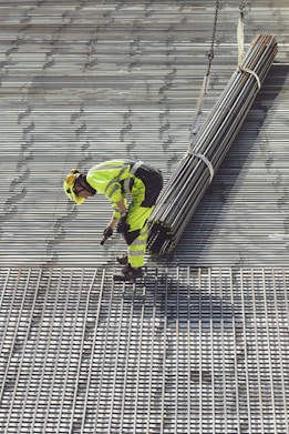 a construction worker working on a metal grate