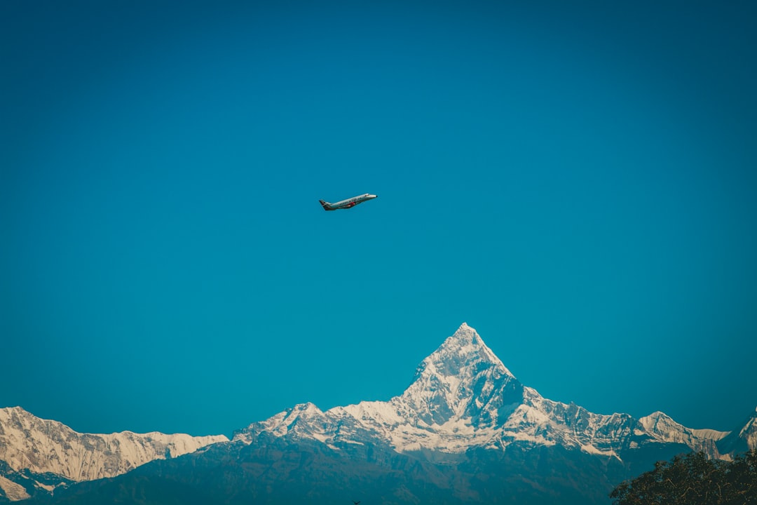 an airplane is flying over a mountain range, Sunset above valley Himalayan mountain near Muktinath track