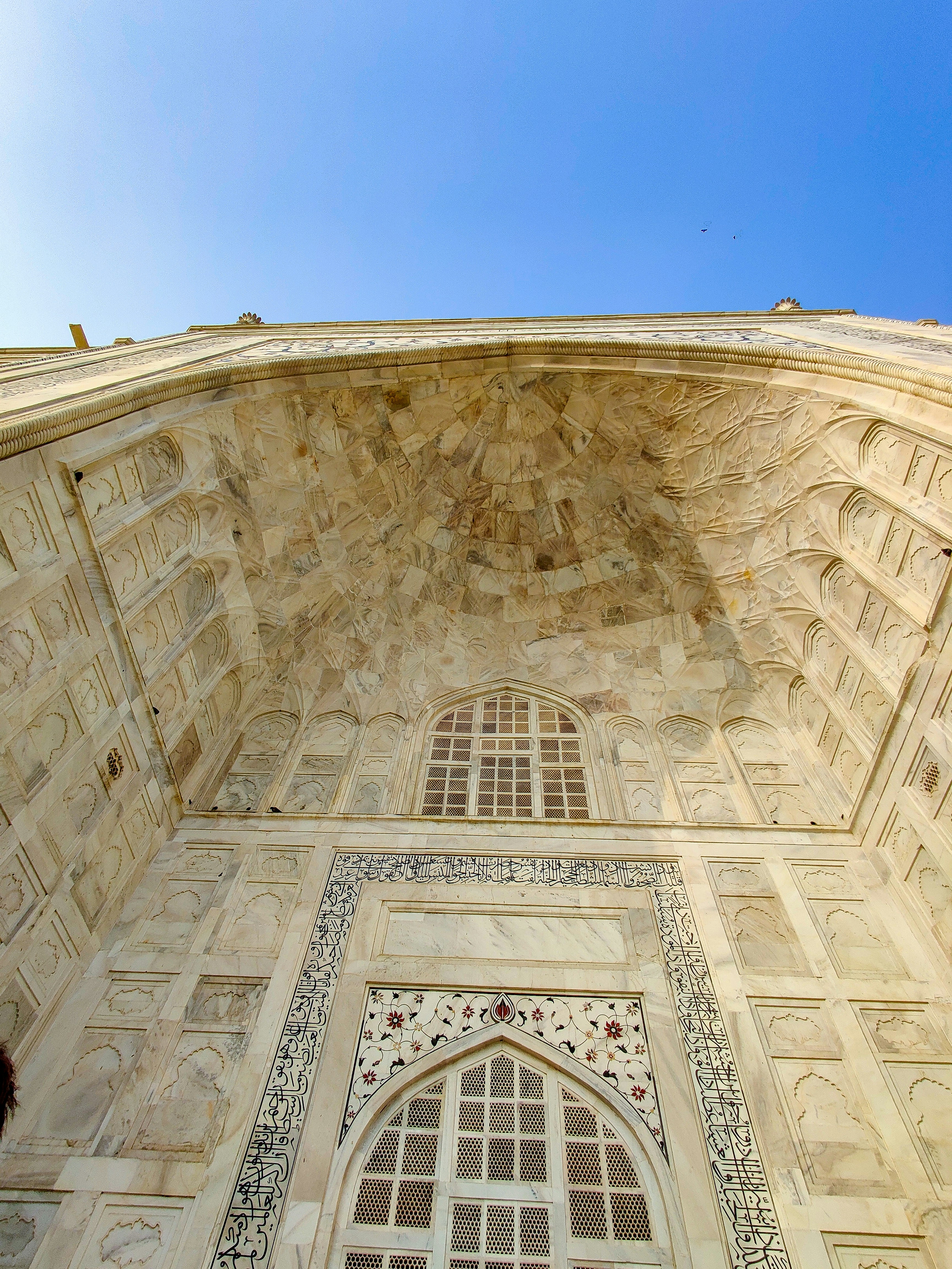 low angle photography of beige concrete building under blue sky during daytime