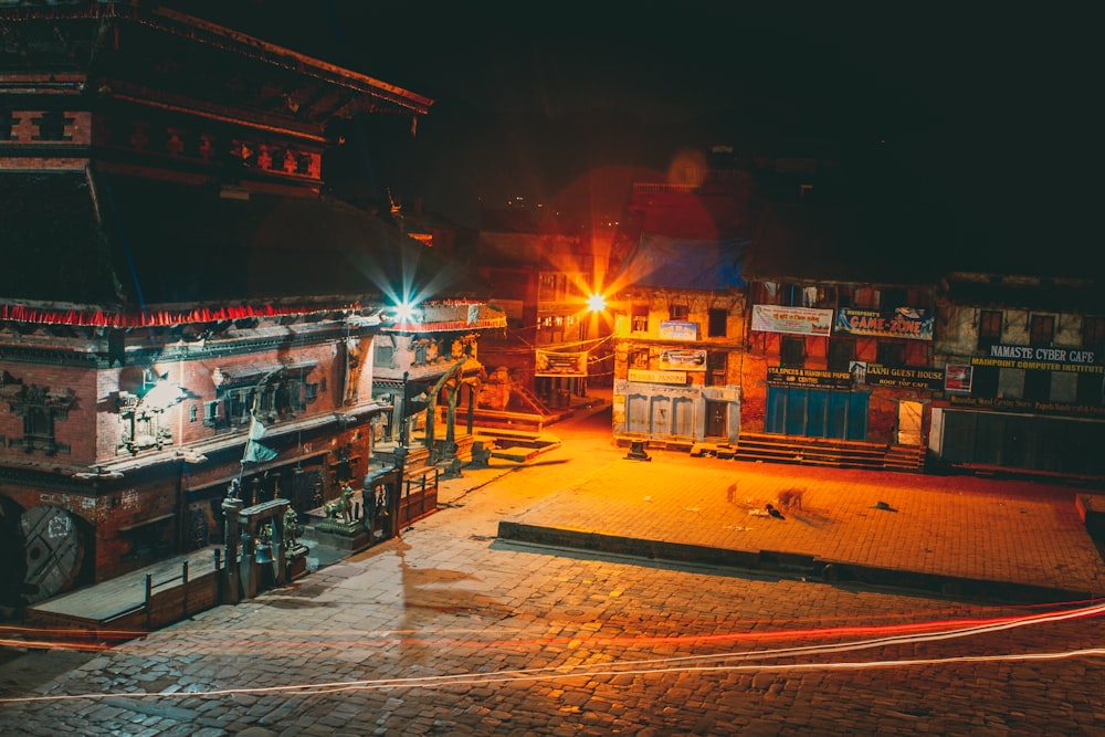 a city street at night with a building lit up