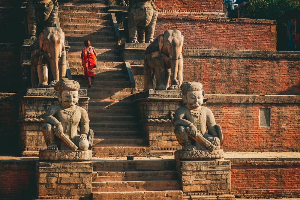 a group of statues sitting on top of stone steps