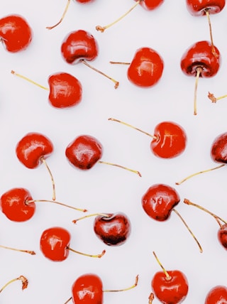 red round fruits on white surface