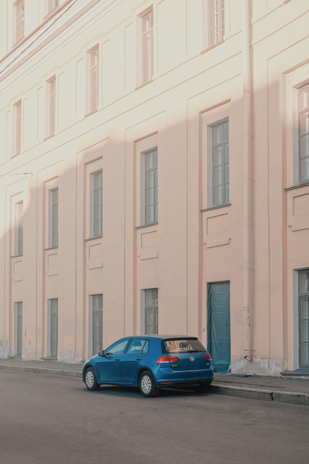 a blue car parked in front of a building