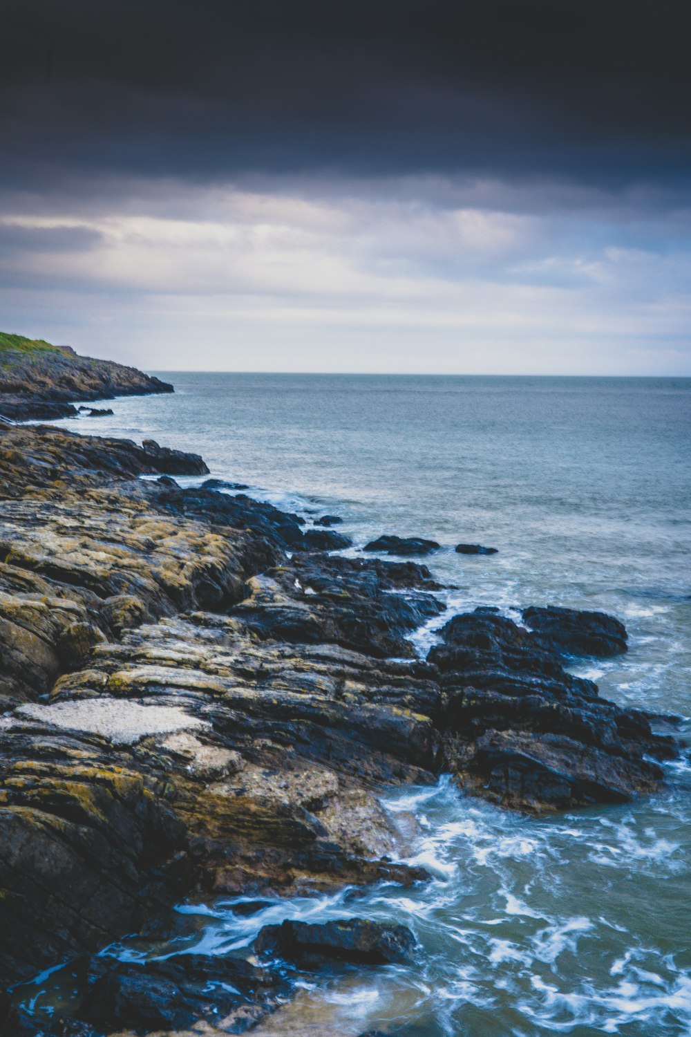 a large body of water sitting next to a rocky shore