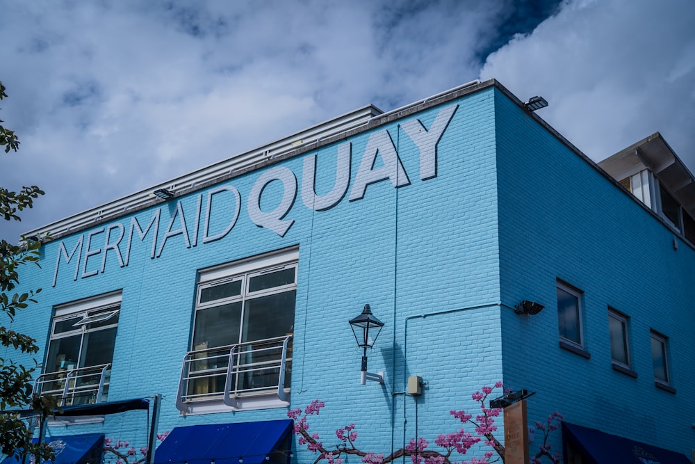 a blue building with the words mermaid quay painted on it
