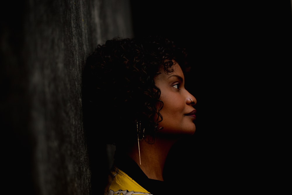 a woman with curly hair looking out of a window