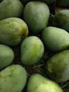 a pile of green fruit sitting on top of grass