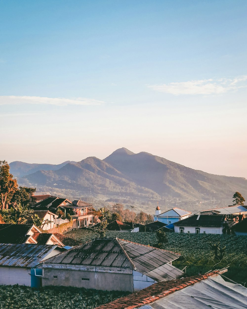 houses near mountain under white clouds during daytime