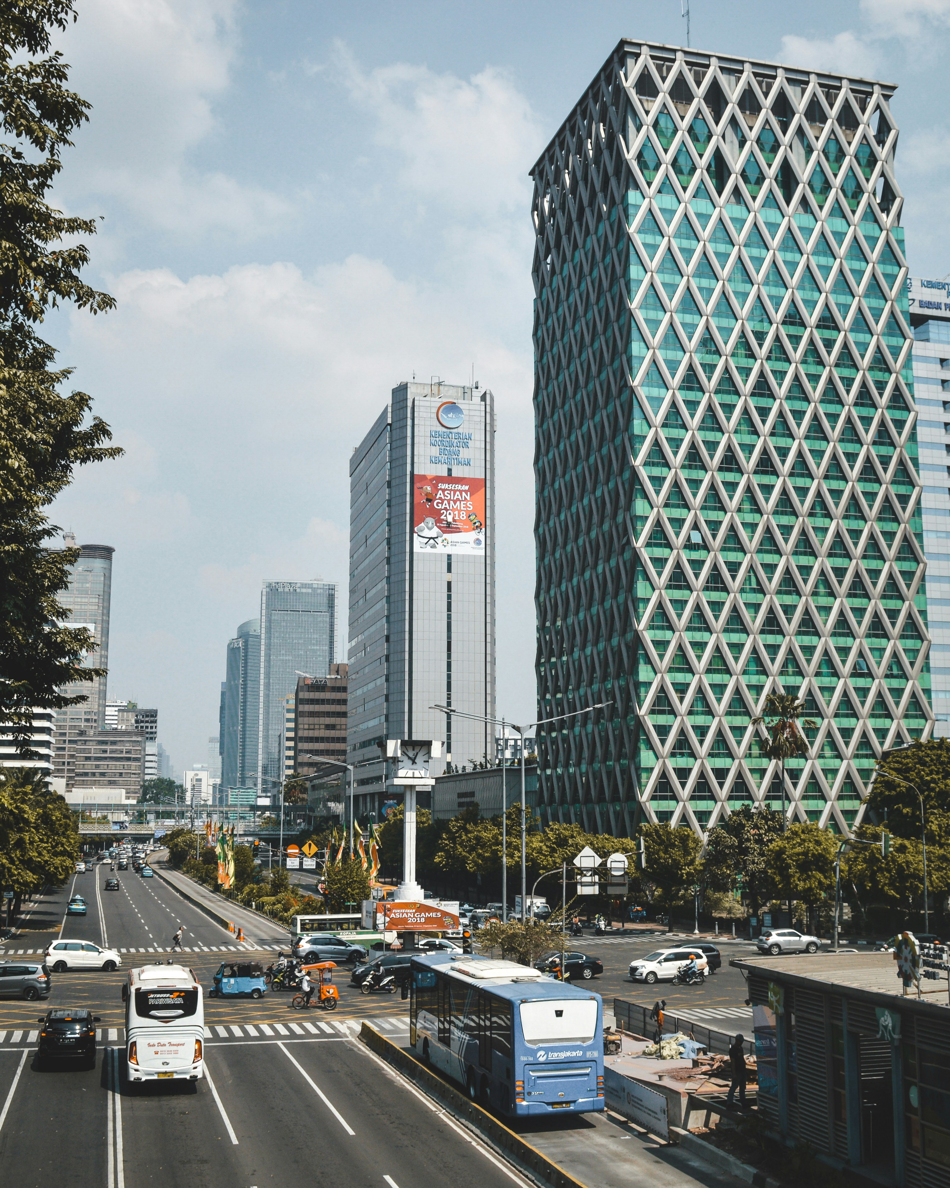 mobil diparkir di tempat parkir dekat gedung bertingkat tinggi pada siang hari