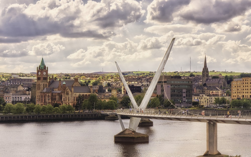 a bridge over a river with a city in the background