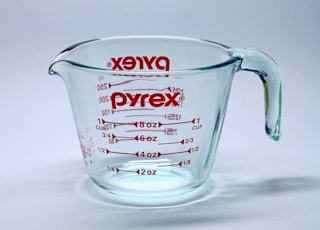 clear glass measuring cup on white surface