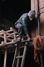 a man climbing up the side of a wooden building