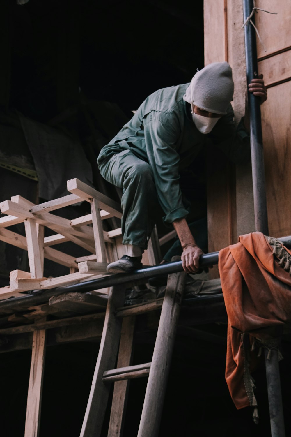 a man climbing up the side of a wooden building