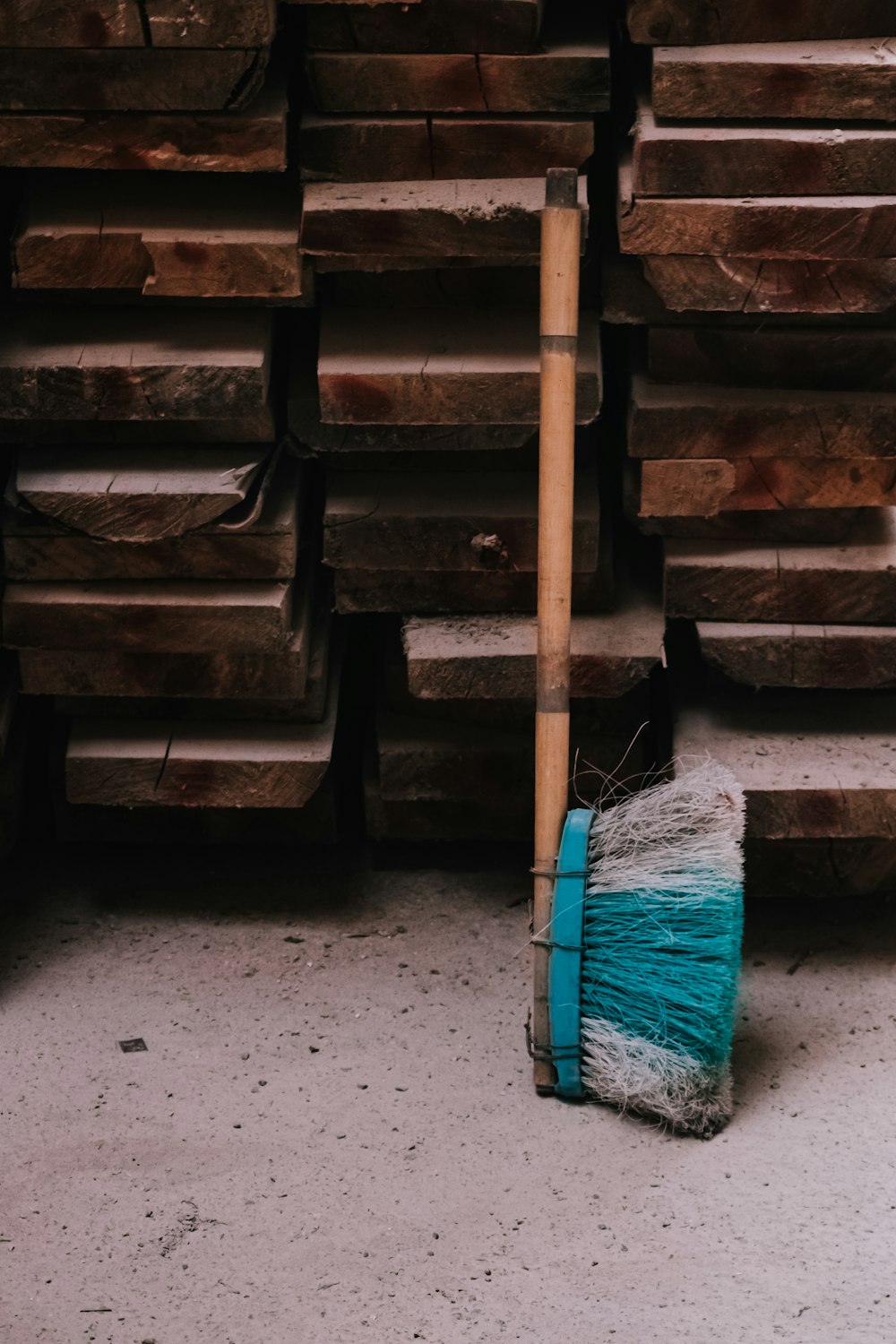 Una escoba sentada junto a un montón de madera