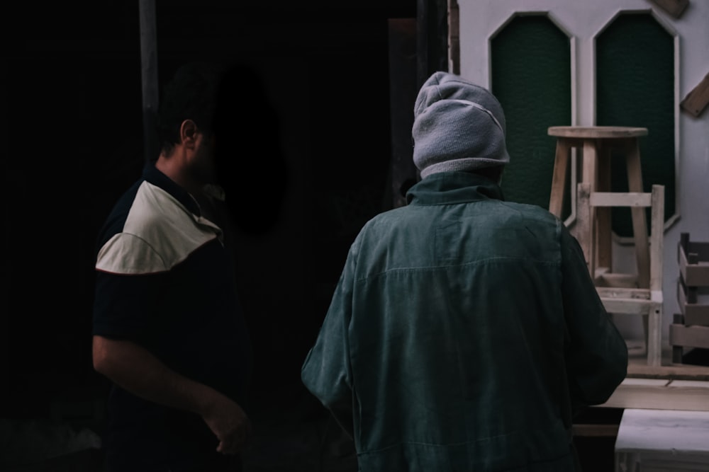 um homem em pé na frente de uma porta preta