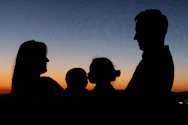 silhouette of 2 men and woman during sunset
