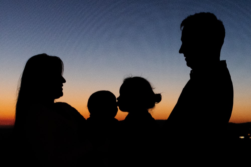 silhouette of 2 men and woman during sunset