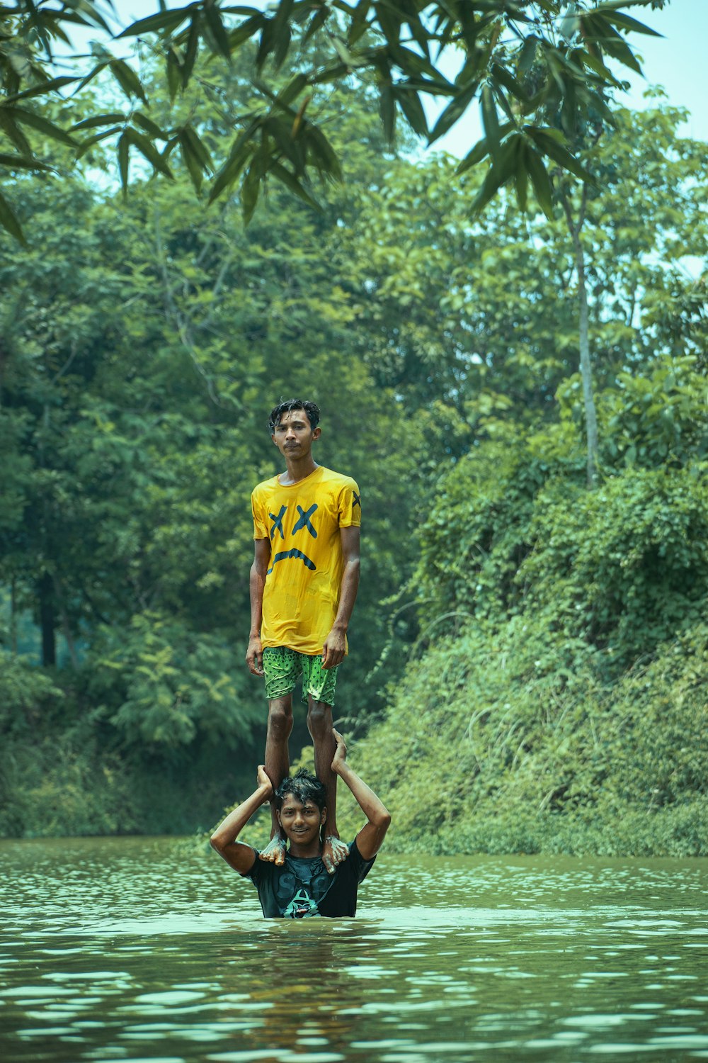 Mann in gelbem Rundhals-T-Shirt und braunen Shorts läuft auf grünem Rasenplatz während