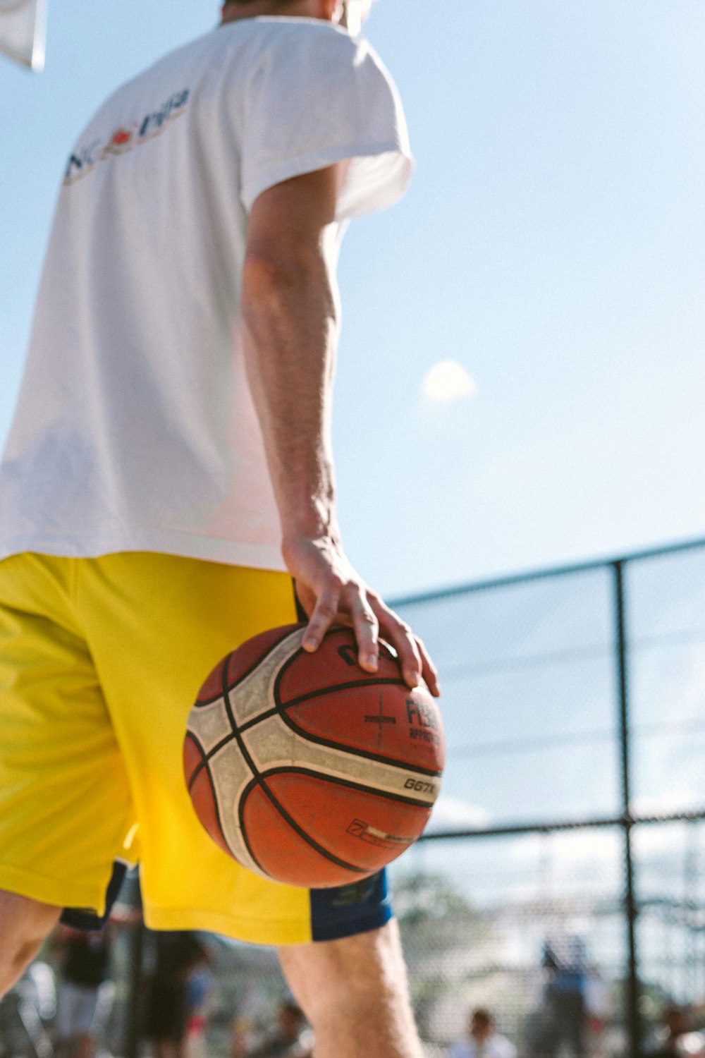 a man holding a basketball on top of a basketball court