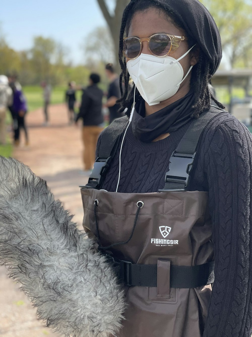 a person wearing a face mask and carrying a bag