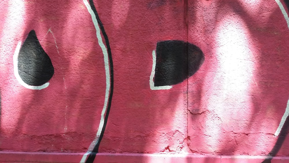 a red wall with some black holes in it