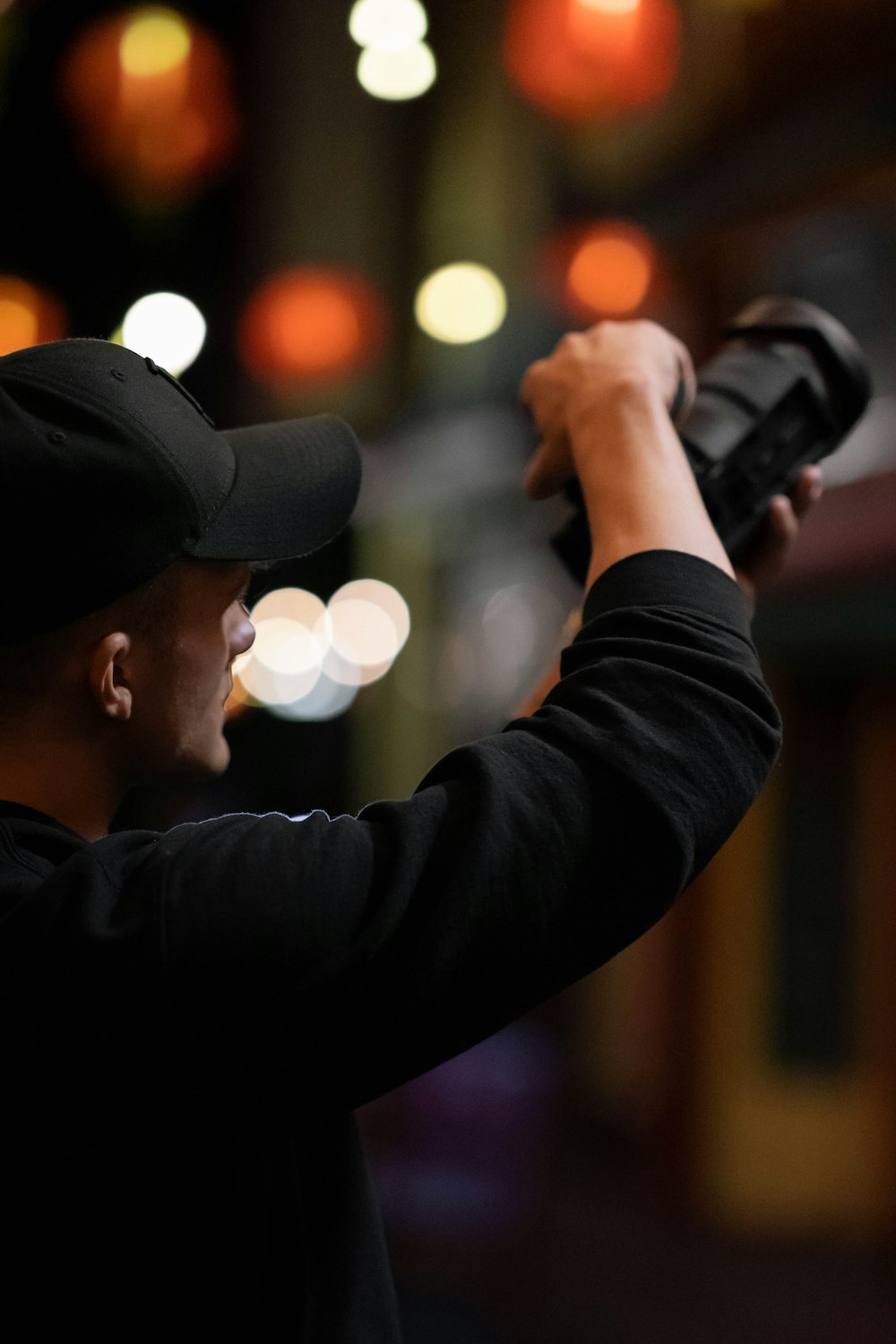 man in black jacket holding black dslr camera