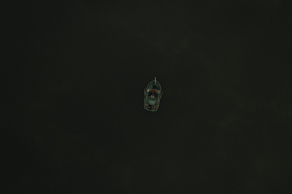 a small boat floating in the dark water