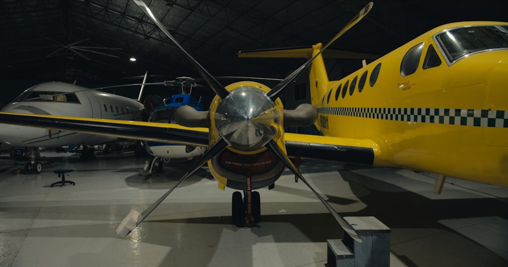 a small yellow airplane parked in a hanger