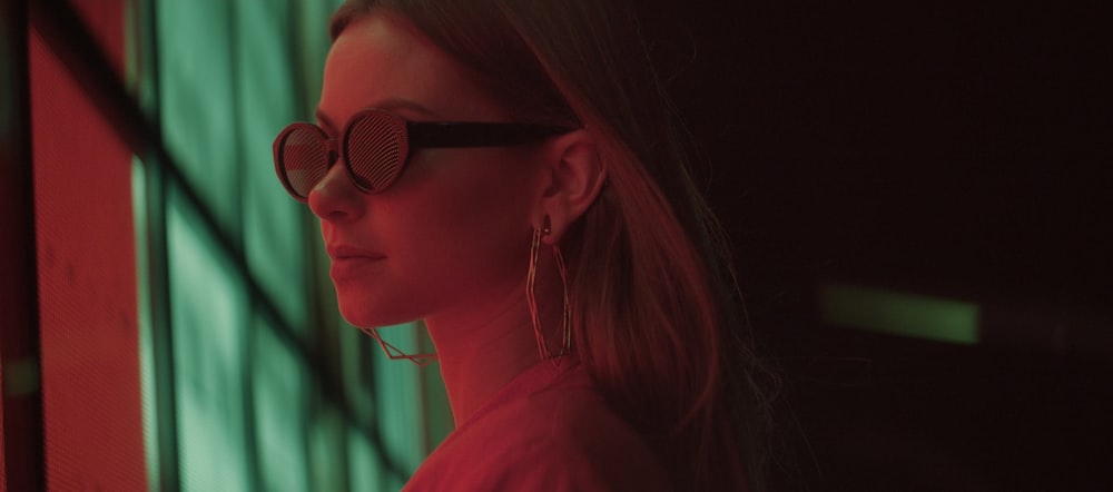 a woman in a red shirt is looking out a window