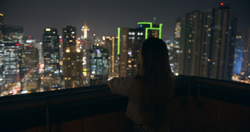 Una donna che guarda su una città di notte