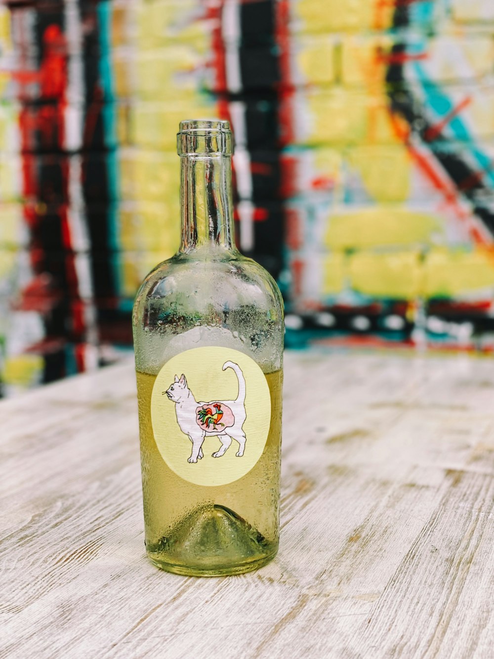 a bottle with a cat sticker on it sitting on a table